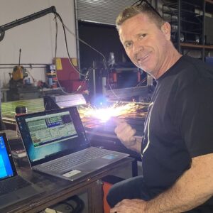 man operating a plasma cutter giving a thumbs up