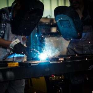 two people welding metal
